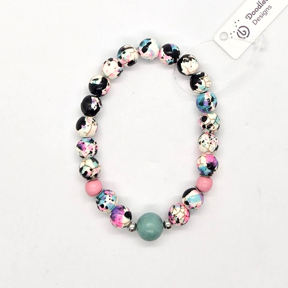 Blue and pink beaded bracelet on a white background with 'Doodlebug Designs' label.
