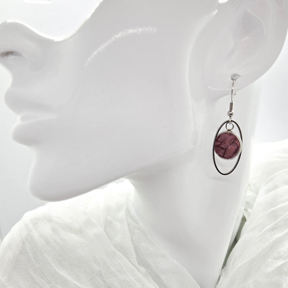 Mauve leather stainless steel earring  on a white mannequin