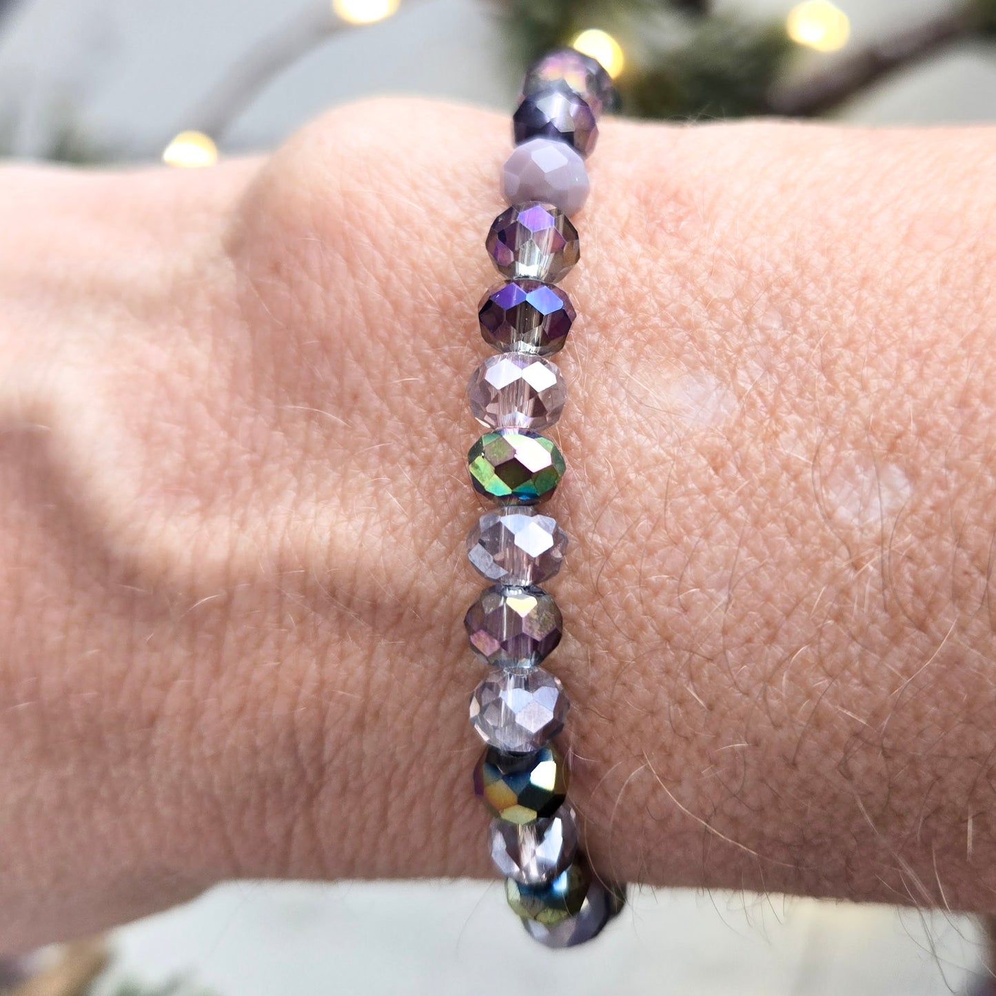 Purple beaded bracelet on a wrist with a blurred background