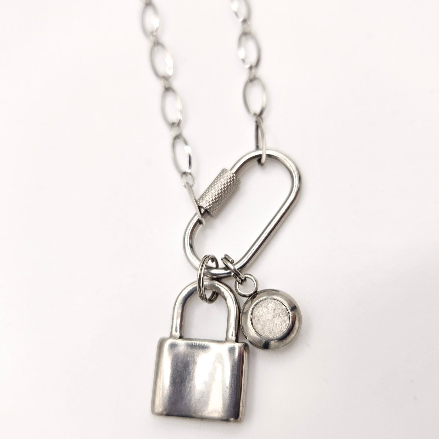 Silver padlock charm necklace on a white background